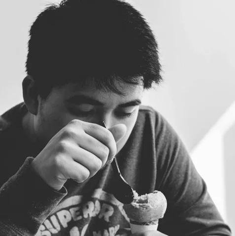 Teenager eating an ice cream hungrily